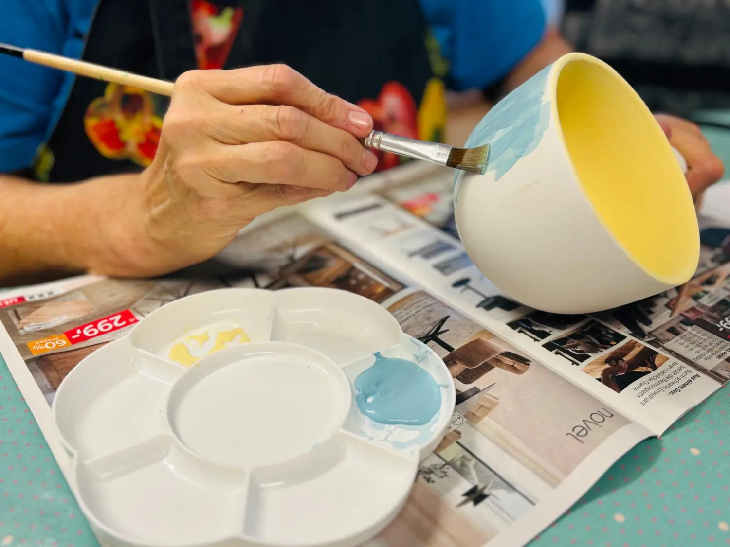 Sentio – eine Person, die eine Tasse bemalt