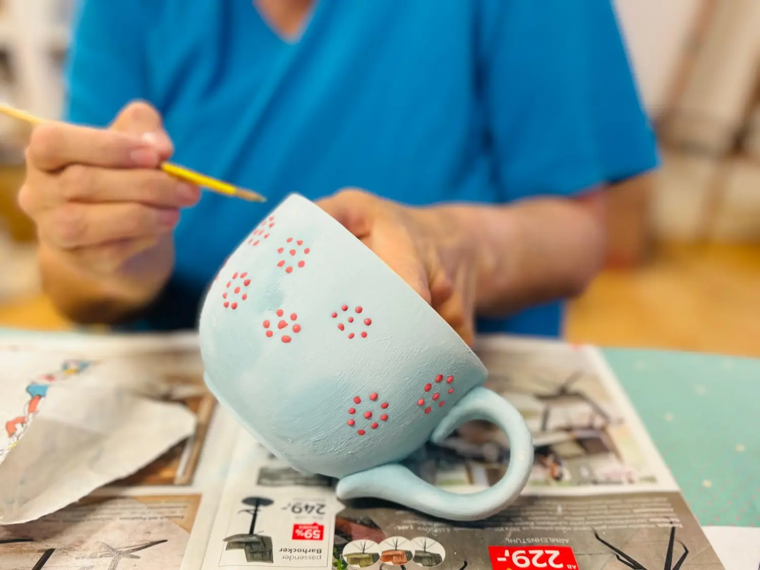 Sentio – eine Person, die eine Tasse bemalt