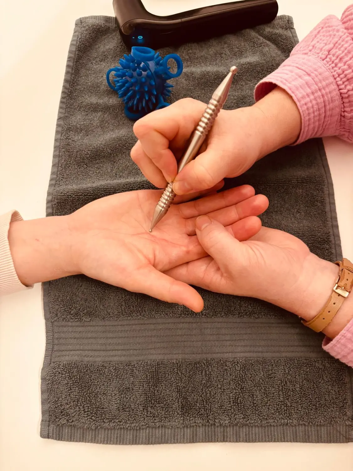 Sentio – eine Person, die eine Form der Handmassage oder Reflexzonenmassage mit einem speziellen Werkzeug erhält